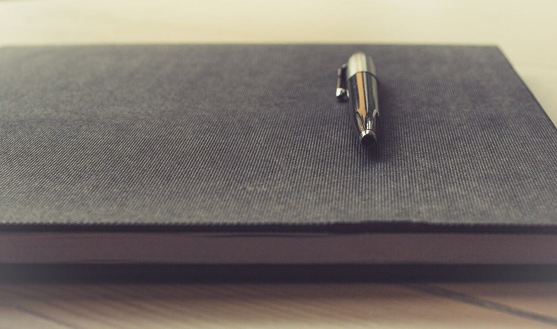 A pen resting on a notebook.
