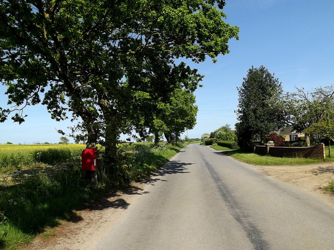 A red postbox in the English countryside.
